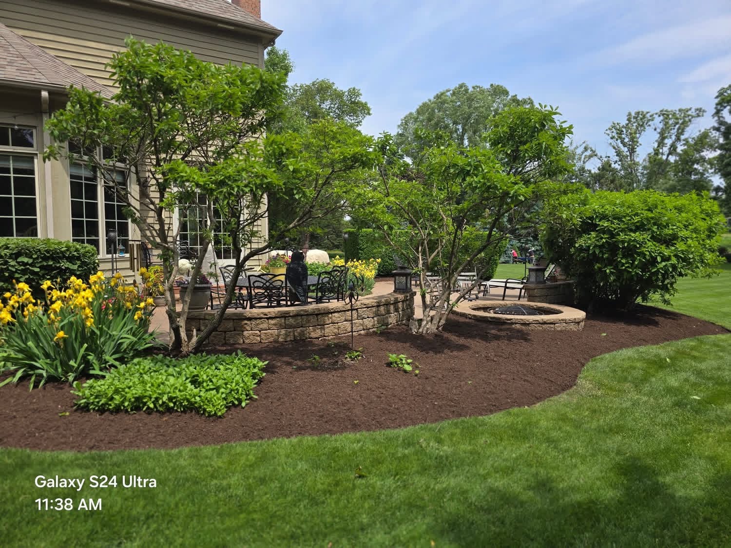 Landscaped patio with fresh mulch and flowering plants